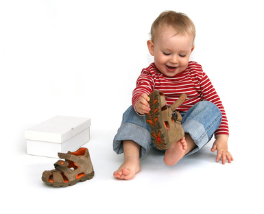 Baby and shoes - child tries to put on shoes