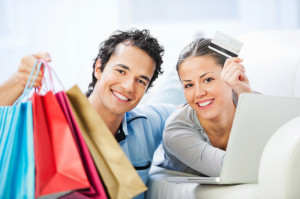 Young couple with laptop, shopping bags  and credit card.