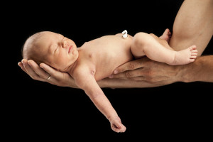 Newborn boy lying on his dad's arms